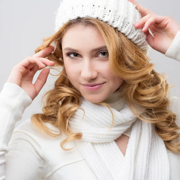 Close-up portrait of a blonde girl in a warm white pullover and hat isolated on white background — Stock Photo, Image