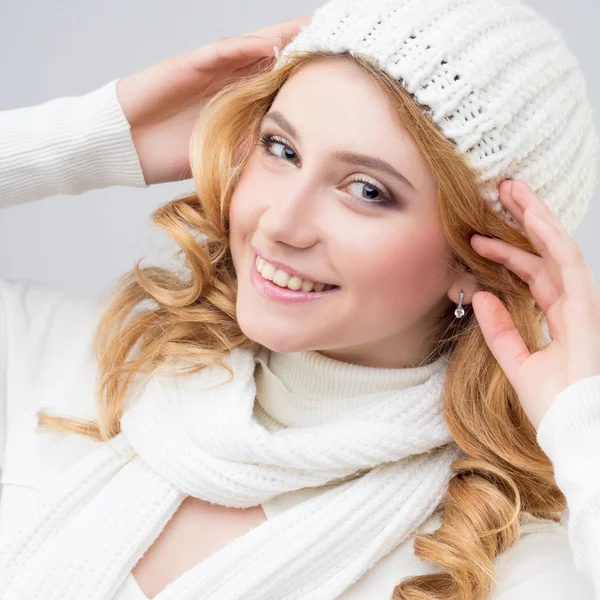 Крупным планом портрет блондинки в теплом белом свитере и шляпе на белом фоне — стоковое фото