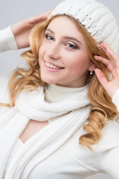 Retrato de cerca de una chica rubia en un jersey blanco cálido y sombrero aislado sobre fondo blanco — Foto de Stock