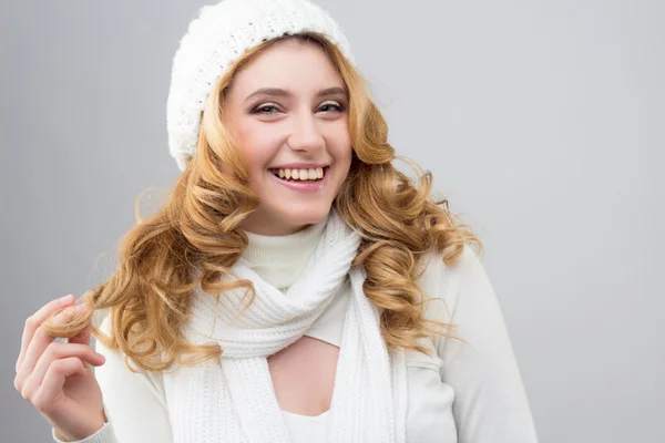 Retrato de cerca de una chica rubia en un jersey blanco cálido y sombrero aislado sobre fondo blanco — Foto de Stock