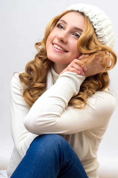 Retrato de cerca de una chica rubia en un jersey blanco cálido y sombrero aislado sobre fondo blanco — Foto de Stock