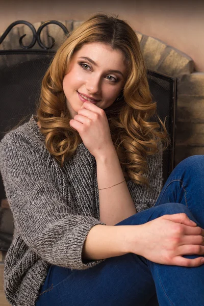 Nahaufnahme Porträt eines jungen blonden Mädchens in grauem Pullover vor weihnachtlichem Hintergrund — Stockfoto