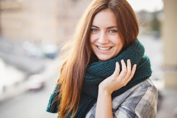 Portrait of young lady wearing green scarf posing on a balcony — Zdjęcie stockowe