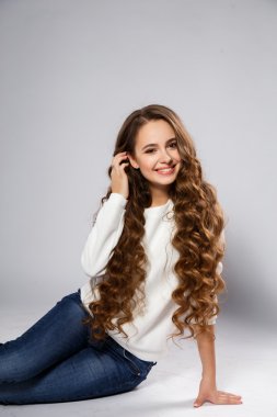 Close-up portrait of beautiful young woman with gorgeous hair and natural makeup wearing casual clothes. Fashion beauty photo, casual jeans style