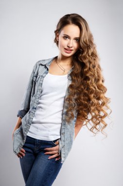 Close-up portrait of beautiful young woman with gorgeous hair and natural makeup wearing casual clothes. Fashion beauty photo, casual jeans style