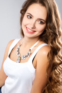 Close-up portrait of beautiful young woman with gorgeous hair and natural makeup wearing casual clothes. Fashion beauty photo, casual jeans style