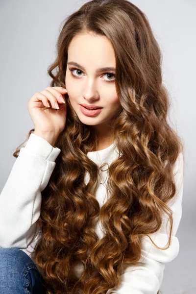 Retrato de cerca de una hermosa mujer joven con hermoso cabello y maquillaje natural. Moda belleza foto — Foto de Stock
