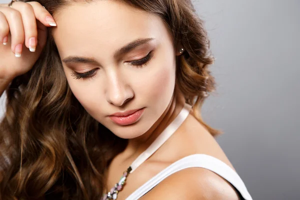 Retrato de cerca de una hermosa mujer joven con hermoso cabello y maquillaje natural. Moda belleza foto — Foto de Stock