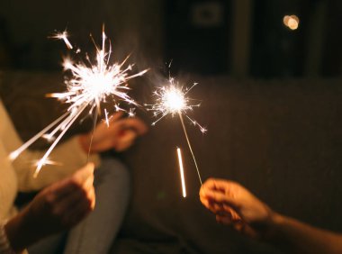 Yanan yeni yıl maytapları. Bengal ışığı küçük parıltılara yayılıyor. Yılbaşını ve 2021 yılını kutluyoruz.