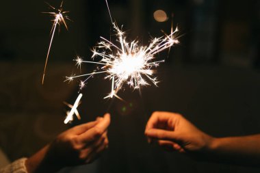 Yanan yeni yıl maytapları. Bengal ışığı küçük parıltılara yayılıyor. Yılbaşını ve 2021 yılını kutluyoruz.
