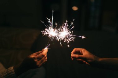 Yanan yeni yıl maytapları. Bengal ışığı küçük parıltılara yayılıyor. Yılbaşını ve 2021 yılını kutluyoruz.
