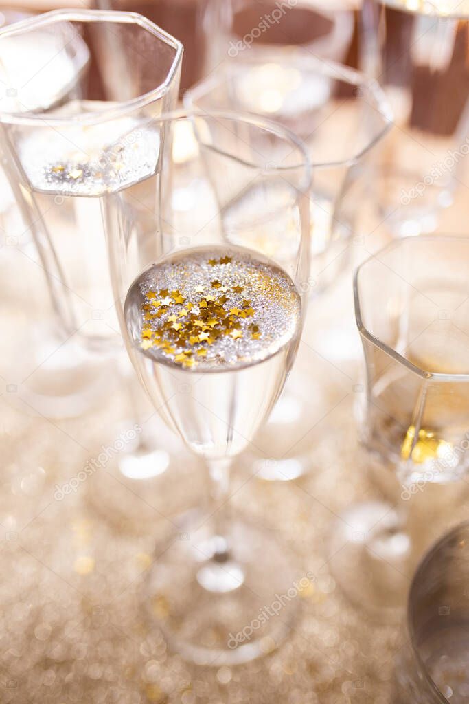 Several champagne glasses over gold christmas background. Celebrating new year concept.