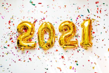Altın folyo balonları 2021 numaralı beyaz arka planda renkli konfeti ile. Mutlu yıllar 2021 kutlamaları..