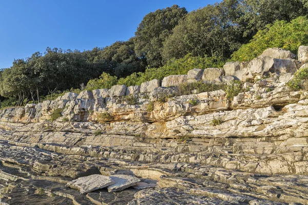 Zonsondergang rotsachtige strand in Istrië, Kroatië. — Stockfoto