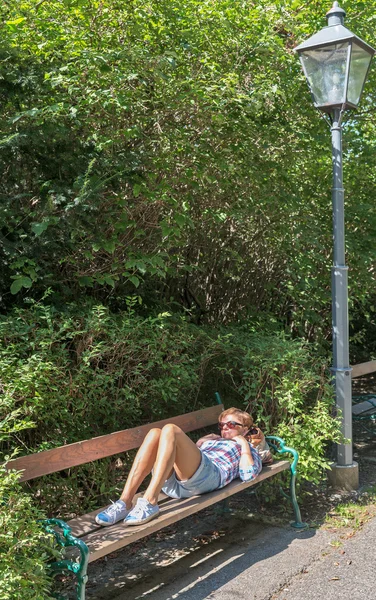 Mulher triste deitada em um banco de parque . — Fotografia de Stock