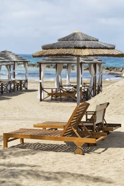 Лежаки и соломенный зонтик для отдыха на морском пляже — стоковое фото