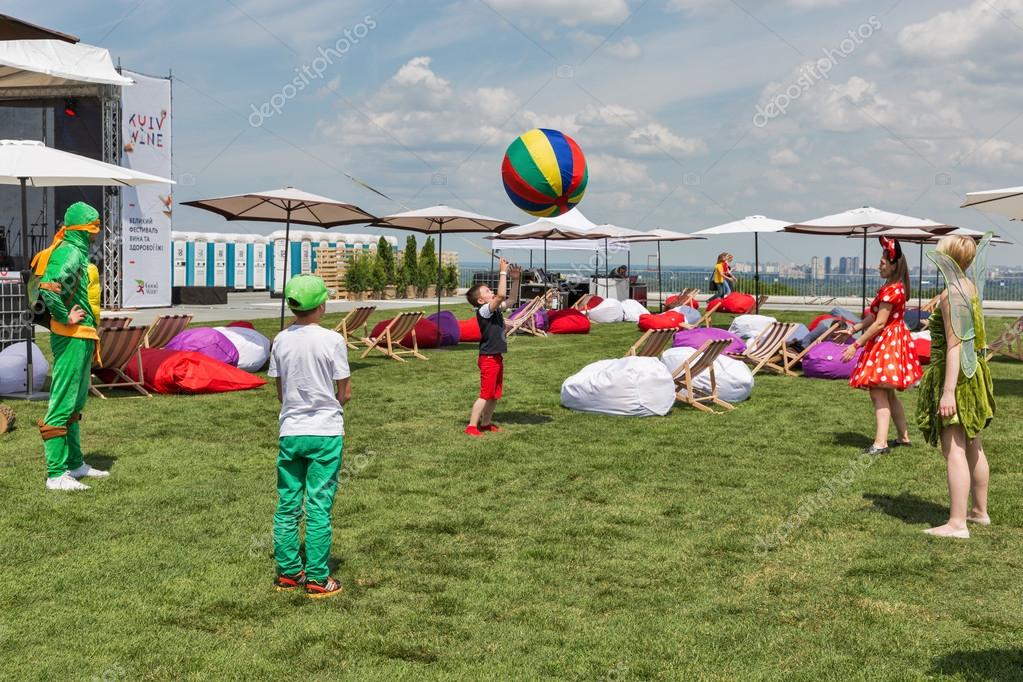 KIEV, UKRAINE - JUNE 04, 2016: Unrecognized children play with animators in lounge zone of outdoor food court at Kyiv Wine Festival organized by Good Wine company in Parkovy Exhibition Center.