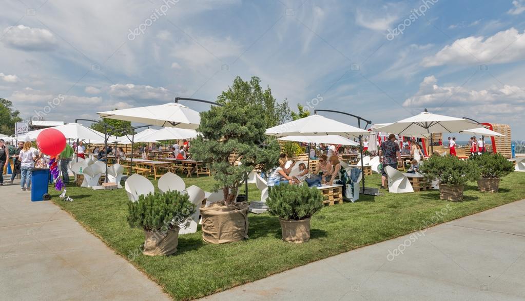 KIEV, UKRAINE - JUNE 04, 2016: Unrecognized people have a rest in lounge zone of outdoor food court at Kyiv Wine Festival organized by Good Wine company in Parkovy Exhibition Center.
