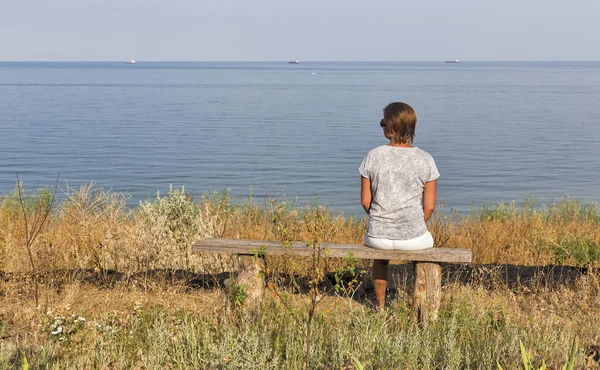 Witte midden leeftijd vrouw zittend op houten bankje met zeegezicht — Stockfoto