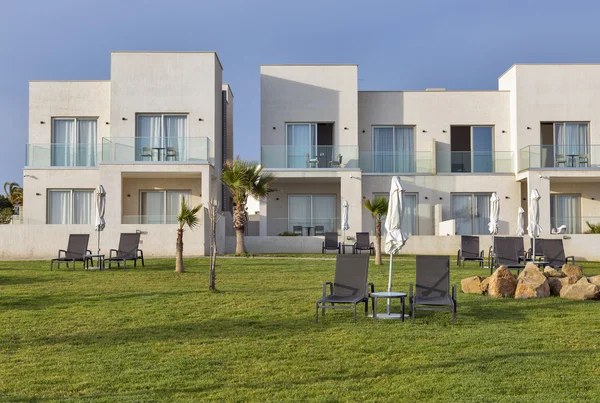 Empty sunbeds with umbrellas on the lawn — Stock Photo, Image