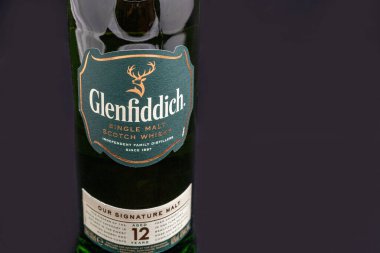 KYIV, UKRAINE - 17 AĞUSTOS 2019: Bir şişe Glenfiddich İskoç viskisi siyaha karşı tek malt viski. Glenfiddich, Galce 'de' Geyik Vadisi 'anlamına gelir, şişedeki geyik sembolünün nedeni.