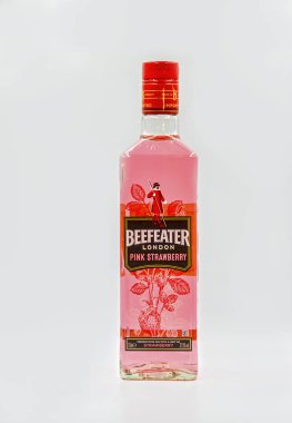 KYIV, UKRAINE - 16 Aralık 2020: Beefeater London Pink Strawberry premium cin şişesi beyaz arka plana yakın plan. Cin ardıç meyvelerinden damıtılmış alkollü bir içecektir..
