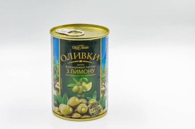 KYIV, UKRAINE - 24 Aralık 2020: Limonla doldurulmuş yeşil zeytin tenekesinin çekimleri beyaz arkaplana karşı.