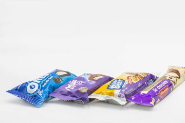 KYIV, UKRAINE - 24 Aralık 2020: Çikolata ve bisküvilerle beyaza yakın çekim yapan farklı yılan kümelerinin stüdyo çekimi. Milka, Oreo, Küçük Ayı, Milenyum.