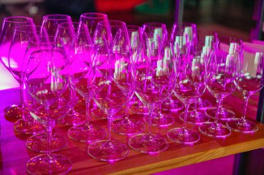 Kırmızı ışıkta yaklaşan boş şarap kadehleri.