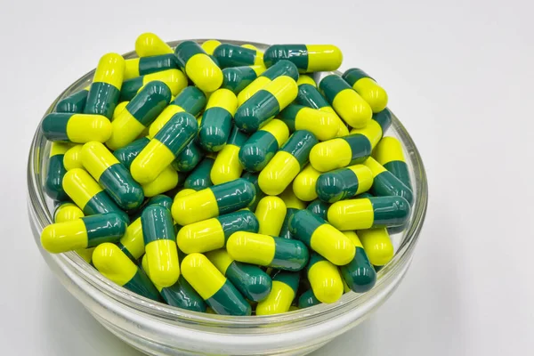 Lékařské Kapsle Žlutá Zelená Skleněné Misce Detailní Bílém Pozadí — Stock fotografie