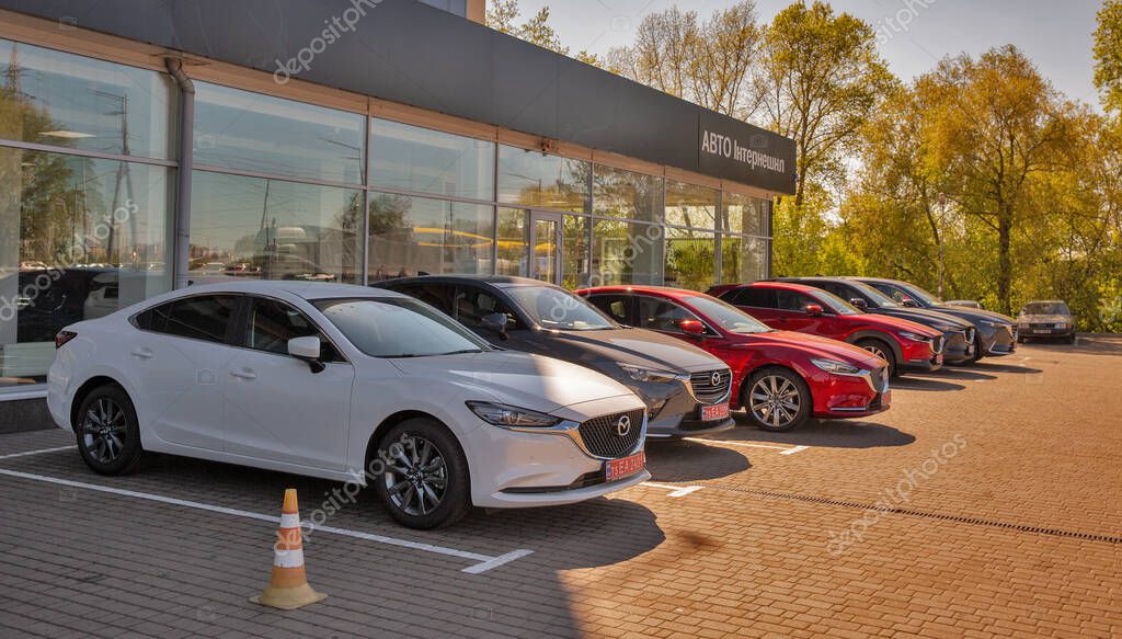 KYIV, UKRAINE - MAY 10, 2021: New Mazda cars on display in front of car dealership Auto International. Cars manufactured in Japan by Mazda Motor Corporation.