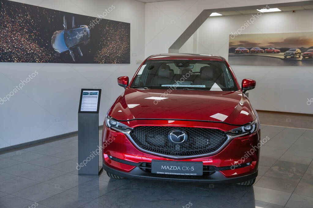 KYIV, UKRAINE - MAY 10, 2021: New red Mazda CX-5 car on display in car dealership Auto International. Crossover SUV manufactured in Japan by Mazda Motor Corporation.