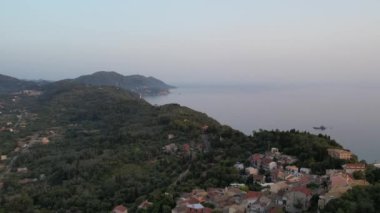 Günbatımında batı kıyısında ve Pelekas köyünde insansız hava aracı görüntüsü. Korfu Adası, Yunanistan.
