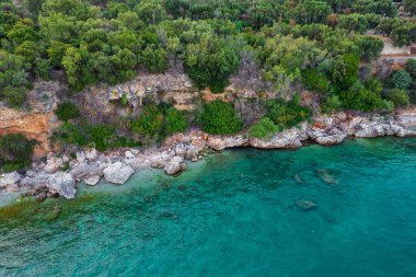 Yunanistan 'ın Corfu adasının doğusundaki Mparmpati' deki kayalık sahil plajı üzerinde insansız hava aracı görüntüsü.