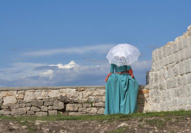 woman in medieval dress looking away from the castle wall clipart