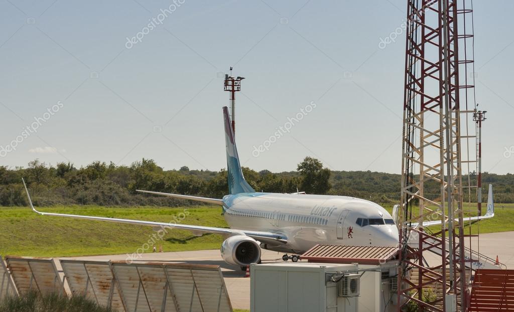 PULA, CROATIA - SEPTEMBER 16, 2014: Luxair jet airplane prepared for boarding and flight on the runway of the airport Zracna Luca. It is located 6 km from the city centre and serves up to 400,000 passengers per year. This airport is a Europe's main c