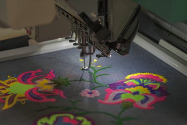 Professional machine for applying embroidery on different tissue clipart