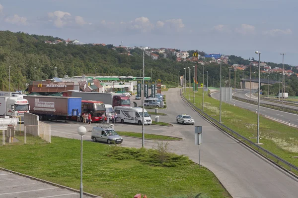 Pessoas e carros no estacionamento em frente ao restaurante McDonald 's e ao posto de gasolina Crodux em Rijeka, Croácia . — Fotografia de Stock
