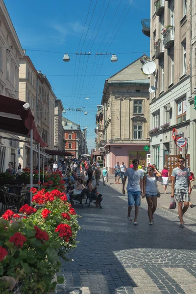 Люди ходят по пешеходной Галицкой улице с кафе и небольшими магазинами — стоковое фото