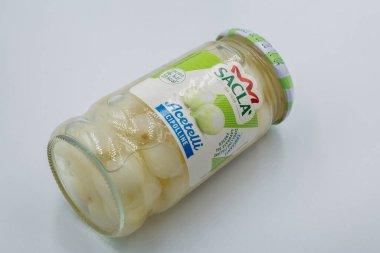 Porec, Hırvatistan - 29 Mayıs 2025: Yeşil ve beyaz etiketli cam kavanozda Sacla marka inci turşulu soğan, beyaz arka planda açık tuzlu suda korunmuş beyaz soğanları gösteriyor.