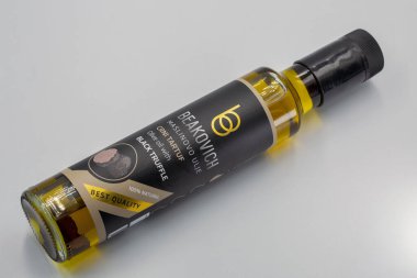 Porec, Hırvatistan - 4 Haziran 2025: Modern sprey dağıtıcısında siyah trüf mantarlı ekstra saf zeytinyağı, beyaz arka planda zarif siyah ve altın ambalaj tasarımı