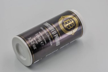 Porec, Hırvatistan - Haziran 04, 2025: Altın aksanlı ve beyaz vida kapaklı zarif siyah silindirik ambalajlı kaliteli trüf tozu. Ürün, gurme çeşnisi içerir..