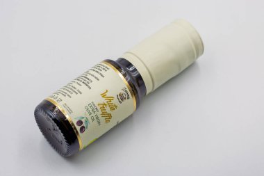 Porec, Hırvatistan - 29 Mayıs 2025: Premium beyaz trüf ekstra saf zeytinyağını küçük kehribar cam şişeye doldurdu, zarif altın senaryo etiketi ve vejetaryen sertifikalı beyaz üzerine yakın çekim rozeti.