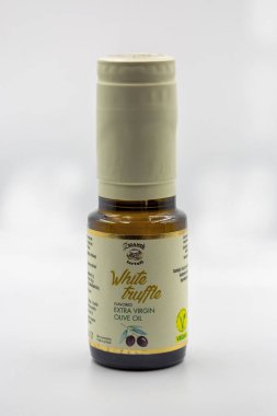 Porec, Hırvatistan - 29 Mayıs 2025: Premium beyaz trüf ekstra saf zeytinyağını küçük kehribar cam şişeye doldurdu, zarif altın senaryo etiketi ve vejetaryen sertifikalı beyaz üzerine yakın çekim rozeti.