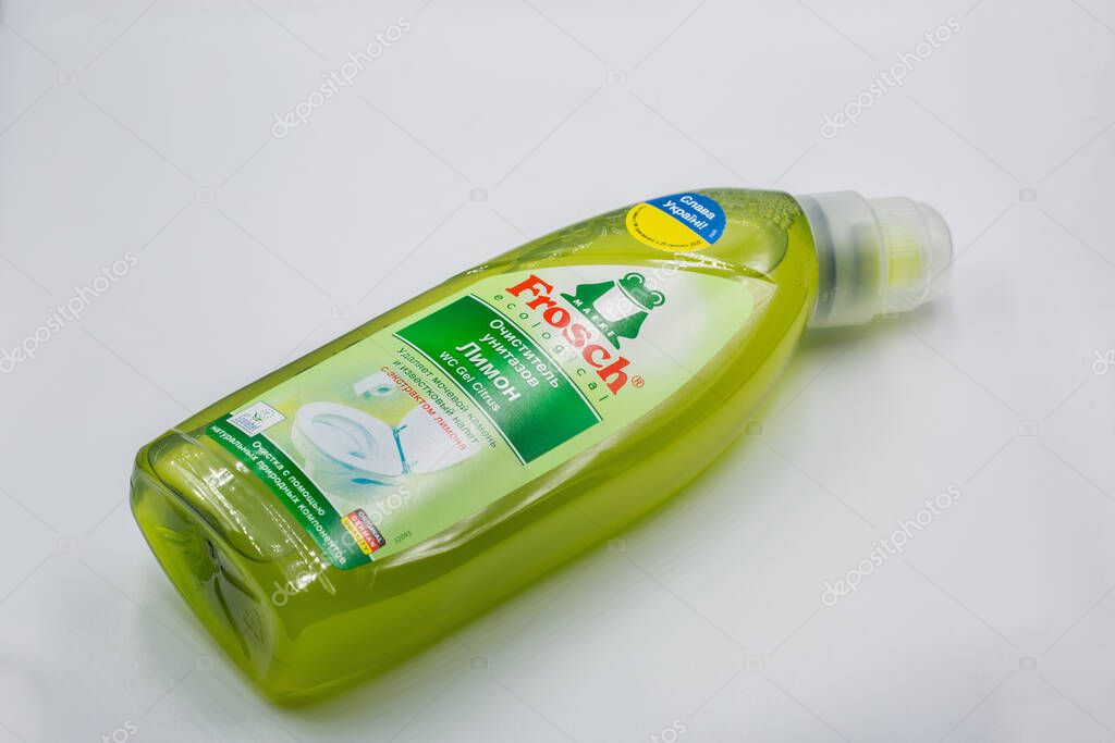 Kyiv, Ukraine - December 01, 2024: Green Frosch ecological dishwashing liquid bottle with lemon scent closeup. German brand eco-friendly dish soap in transparent plastic bottle on white surface.