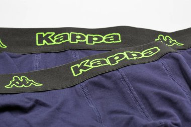 Kyiv, Ukrayna - Haziran 04, 2025: Kappa atletik iç çamaşırına yakın çekim: Siyah elastik kemerli lacivert kumaş parlak neon yeşil logolar ve sembolik Omini figürleri sergiliyor.