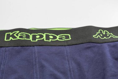 Kyiv, Ukrayna - Haziran 04, 2025: Kappa atletik iç çamaşırına yakın çekim: Siyah elastik kemerli lacivert kumaş parlak neon yeşil logolar ve sembolik Omini figürleri sergiliyor.