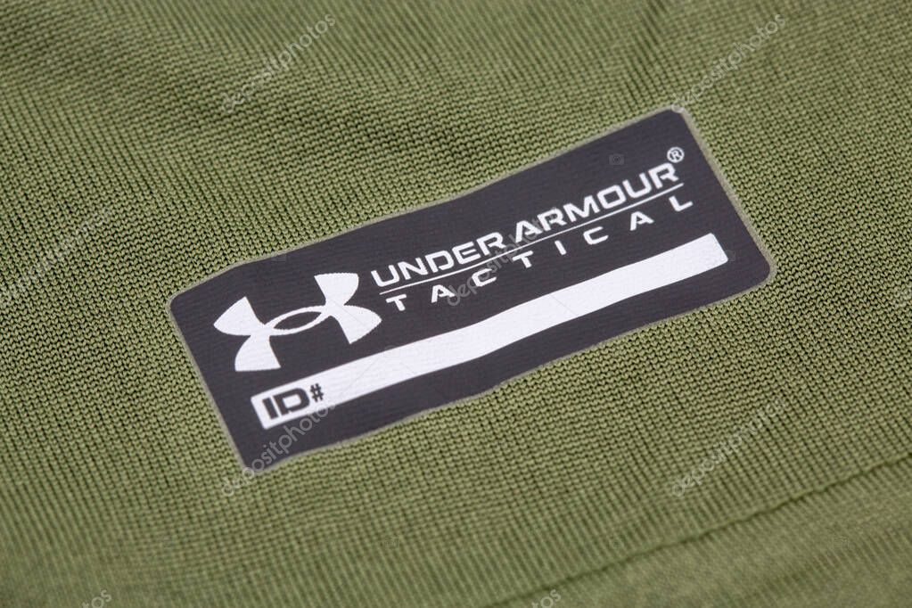 Kyiv, Ukraine - June 23, 2025: Olive green Under Armour loose fit athletic shirt with black branded tag and iconic logo closeup.