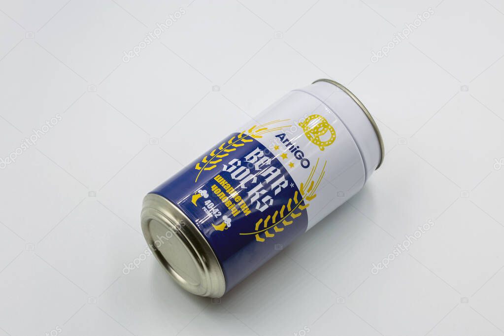 Kyiv, Ukraine - January 05, 2025: Studio shoot of Amigo brand bear men socks in beer can styled tin packaging. Blue and white design with pretzel and wheat motifs in creative novelty gift container.