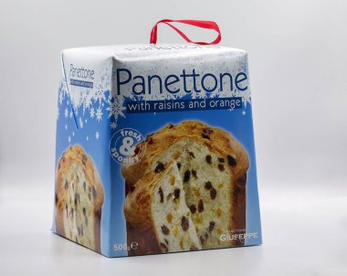 Kyiv, Ukrayna - 21 Aralık 2024: Kuru üzüm ve turuncu aromalı kutulu İtalyan panettonu, kırmızı kurdele saplı bayram mavisi ambalaja sarılmış, beyaz arka plan kapağında sergilenmektedir..